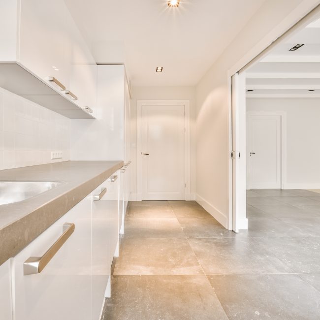 Interior of modern kitchen with white furniture
