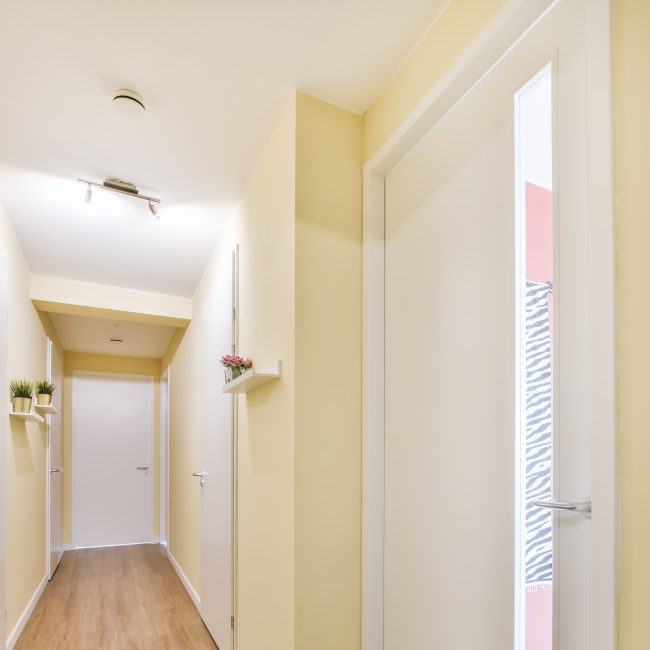 Stylish long corridor with yellow walls